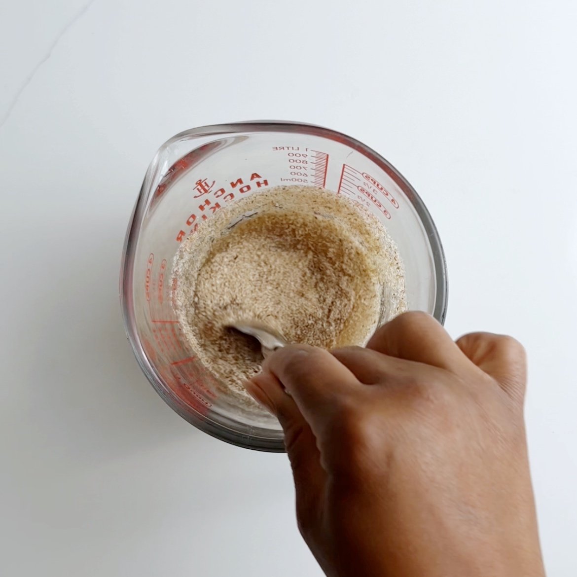 Mixing psyllium husk and water in a glass measuring cup