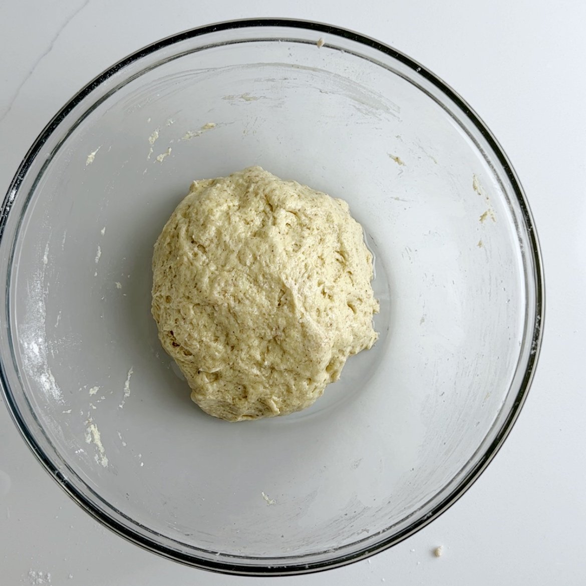 Gluten free bara dough shaped into a ball and topped with oil in a glass mixing bowl