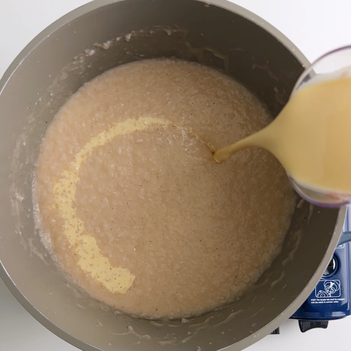 Adding evaporated milk to the finished rice porridge