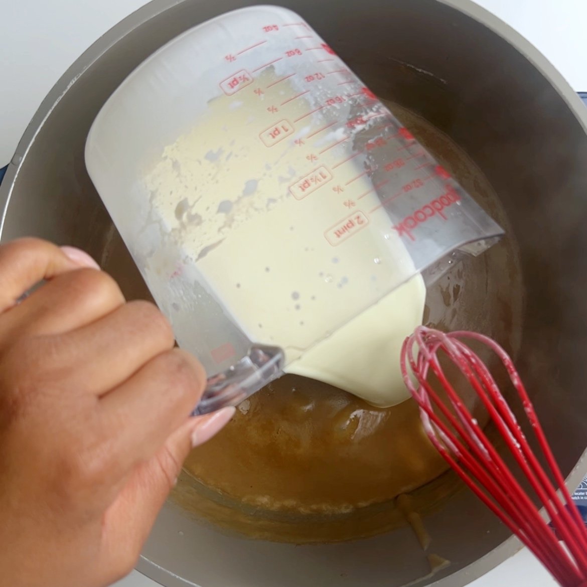 Pouring milk into a pot of boiling flour porridge