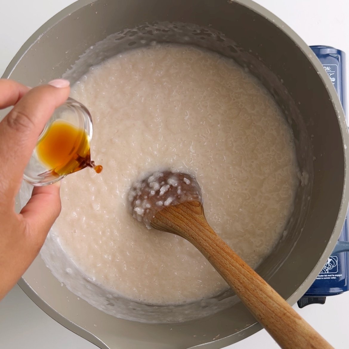 Adding vanilla extract to a pot of rice porridge