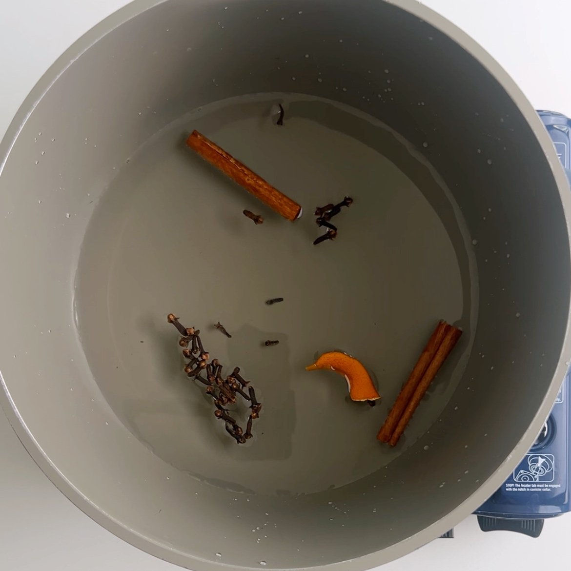 Adding water and spices to a pot to make rice porridge