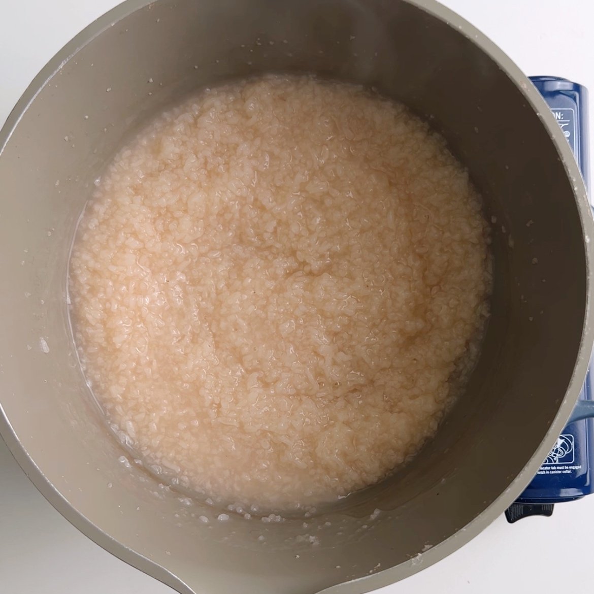Cooked broken rice in a gray pot