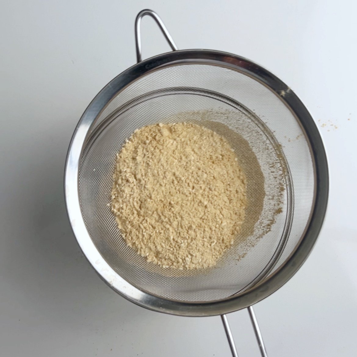 Shifting parch flour with a wire sieve.