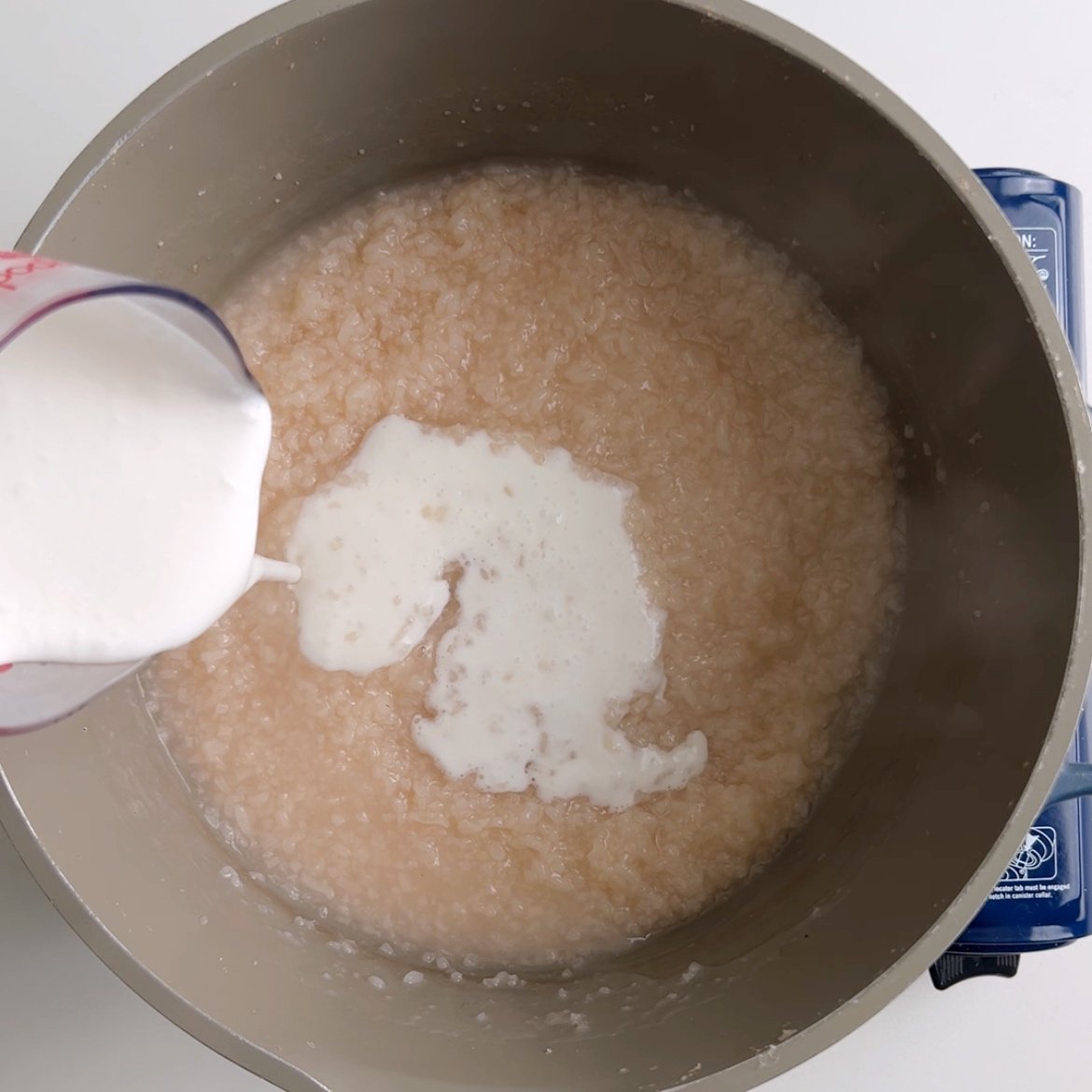 Adding coconut milk to rice porridge