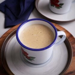 a cup of flour porridge sitting o a saucer with another right behind it