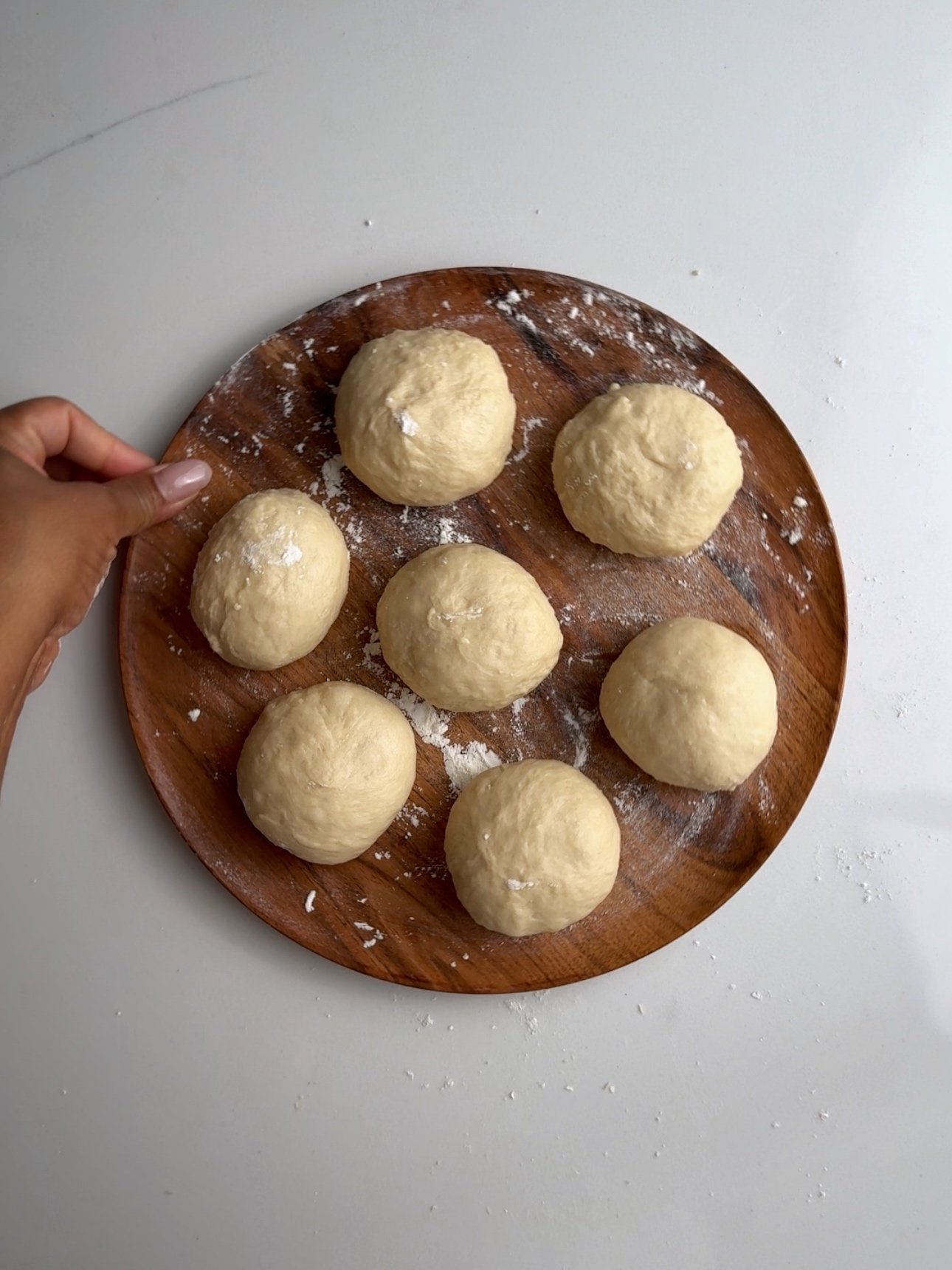 bake dough rolled out into balls on a wooden plate