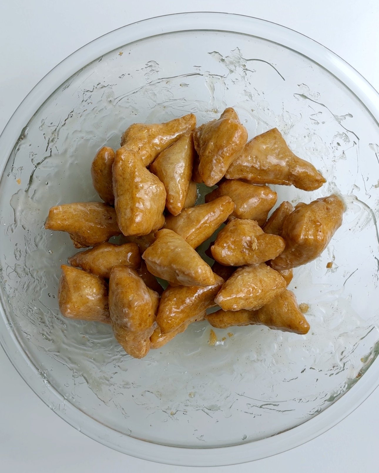 Mithai pieces coated in sugar resting in a glass bowl