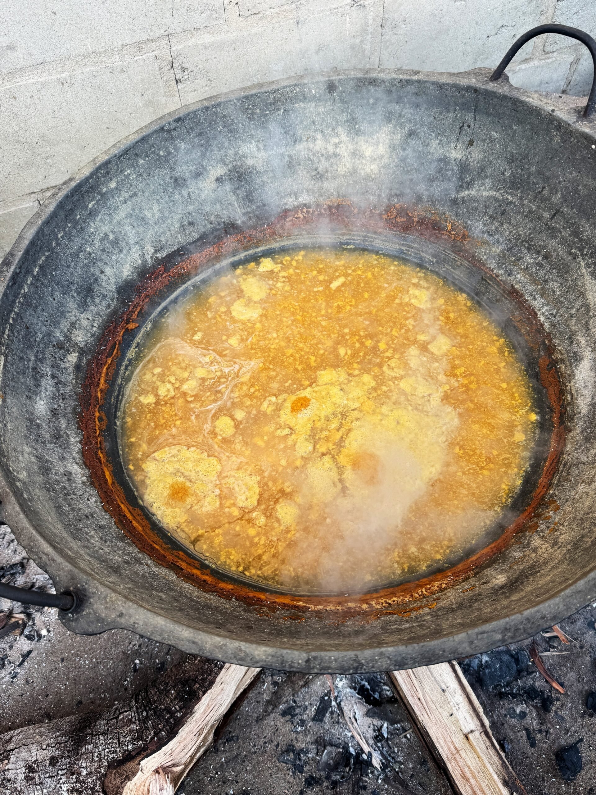 Cassava water in a pot over a wood fire. 