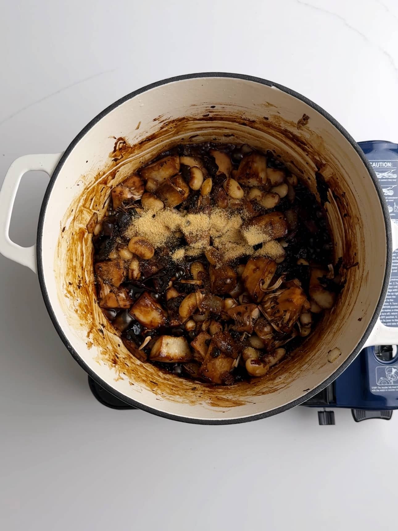 Cooking vegan pepperpot in a dutch oven.