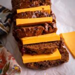 Sliced Jamaican Easter bun served with thick slices of cheese stacked between each piece.