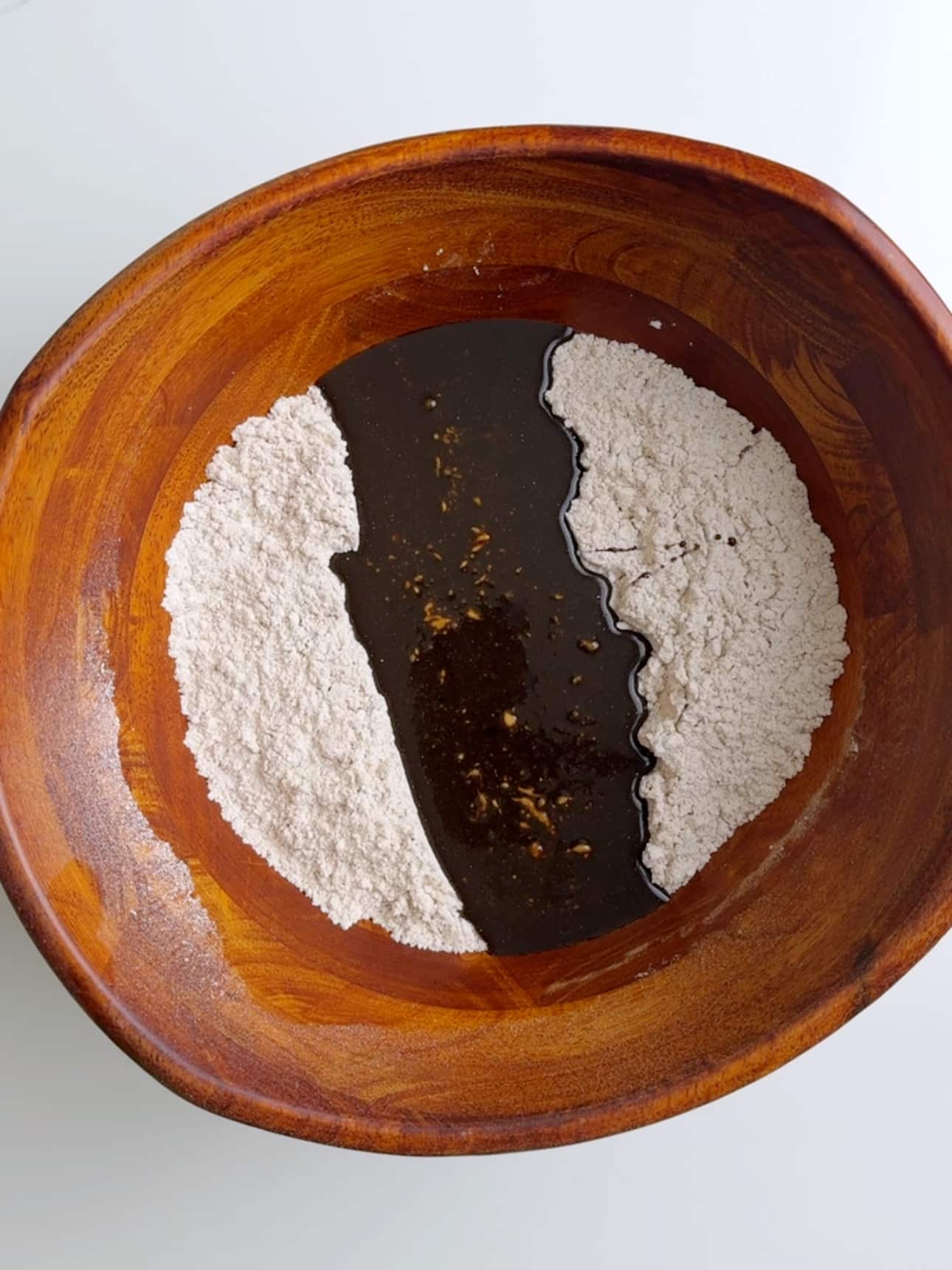 Molasses and browning added to gluten free flour in a mixing bowl.