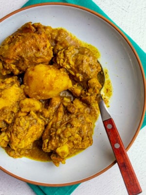 Close-up of Instant pot curry with tender chicken pieces and potatoes coated in a rich yellow curry sauce.