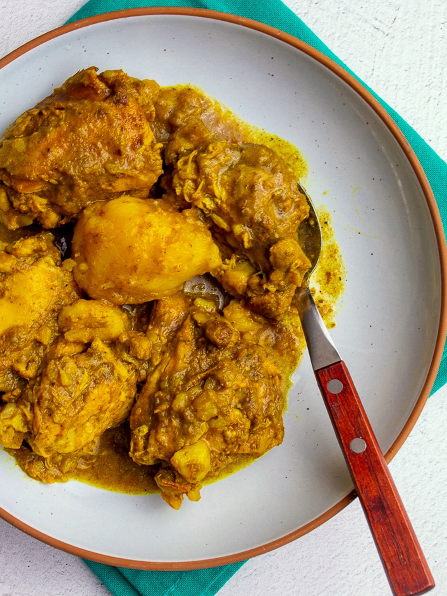 Close-up of Instant pot curry with tender chicken pieces and potatoes coated in a rich yellow curry sauce.