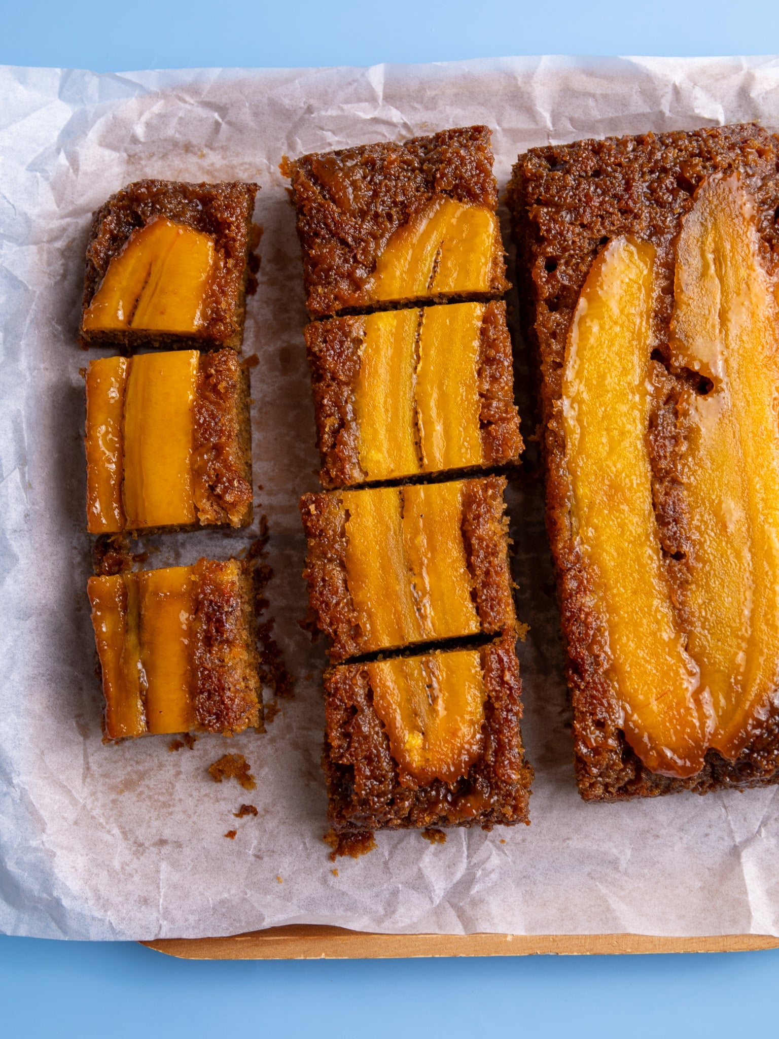 Sliced pieces of caramelized plantain bread showing moist texture and plantain topping.