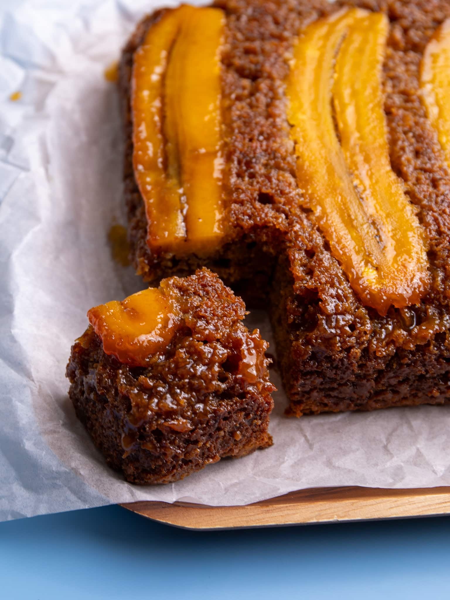 Angled close-up of caramelized plantain bread showing the moist texture and shiny plantain topping.