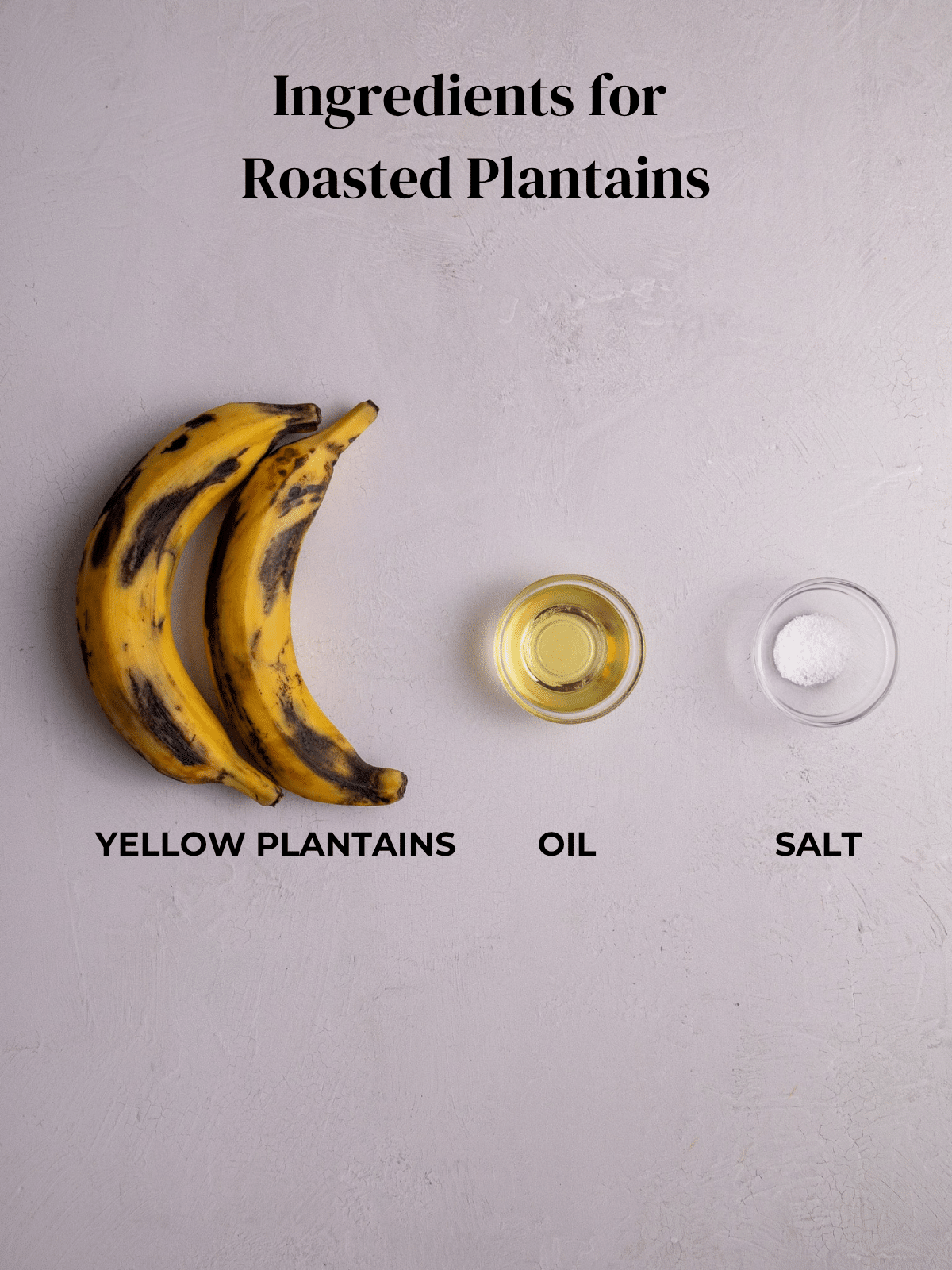 Two ripe yellow plantains sit beside small bowls of oil and salt labeled as ingredients for roasted plantains.