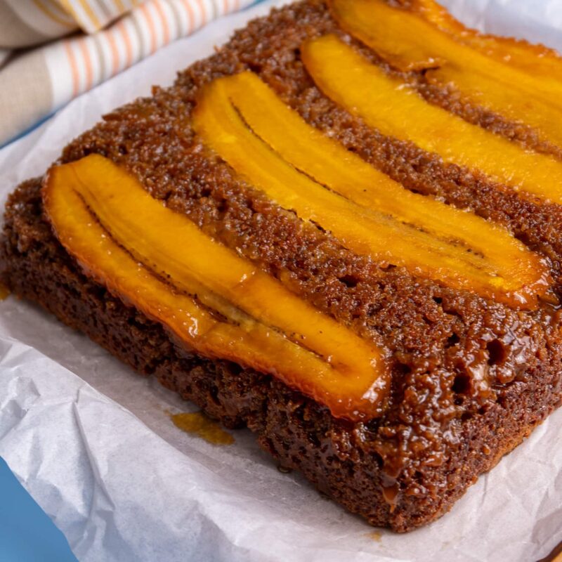 Angled close-up of caramelized plantain bread showing the moist texture and shiny plantain topping.