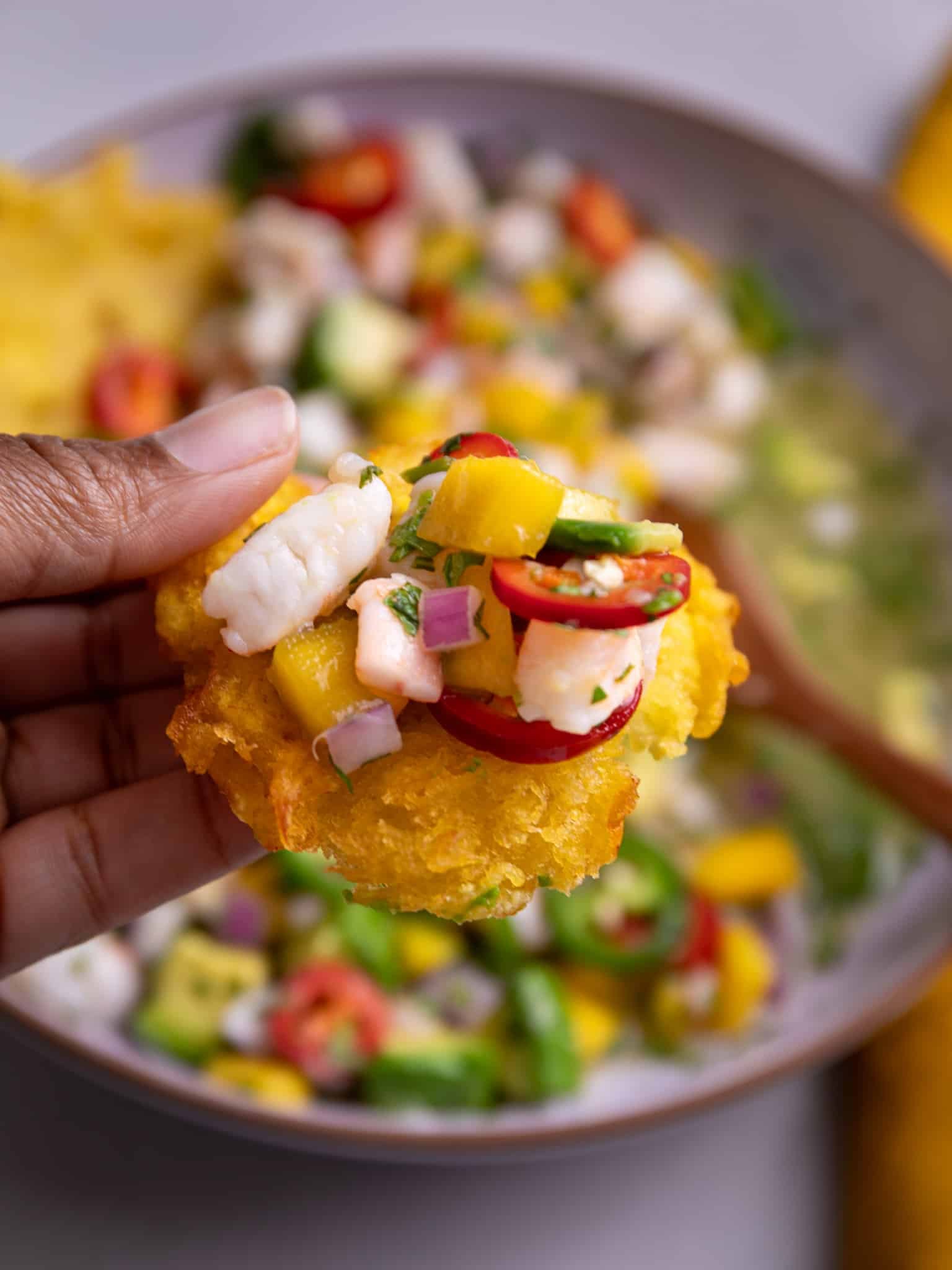 tostone topped with shrimp ceviche, mango, avocado, and peppers