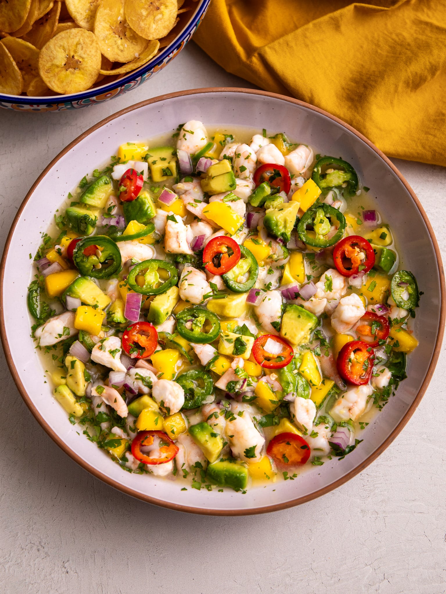 Shrimp ceviche with mango, avocado, jalapeños, and lime juice served with plantain chips